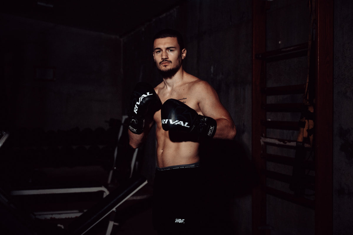 Boxer with black boxing gloves standing in guard