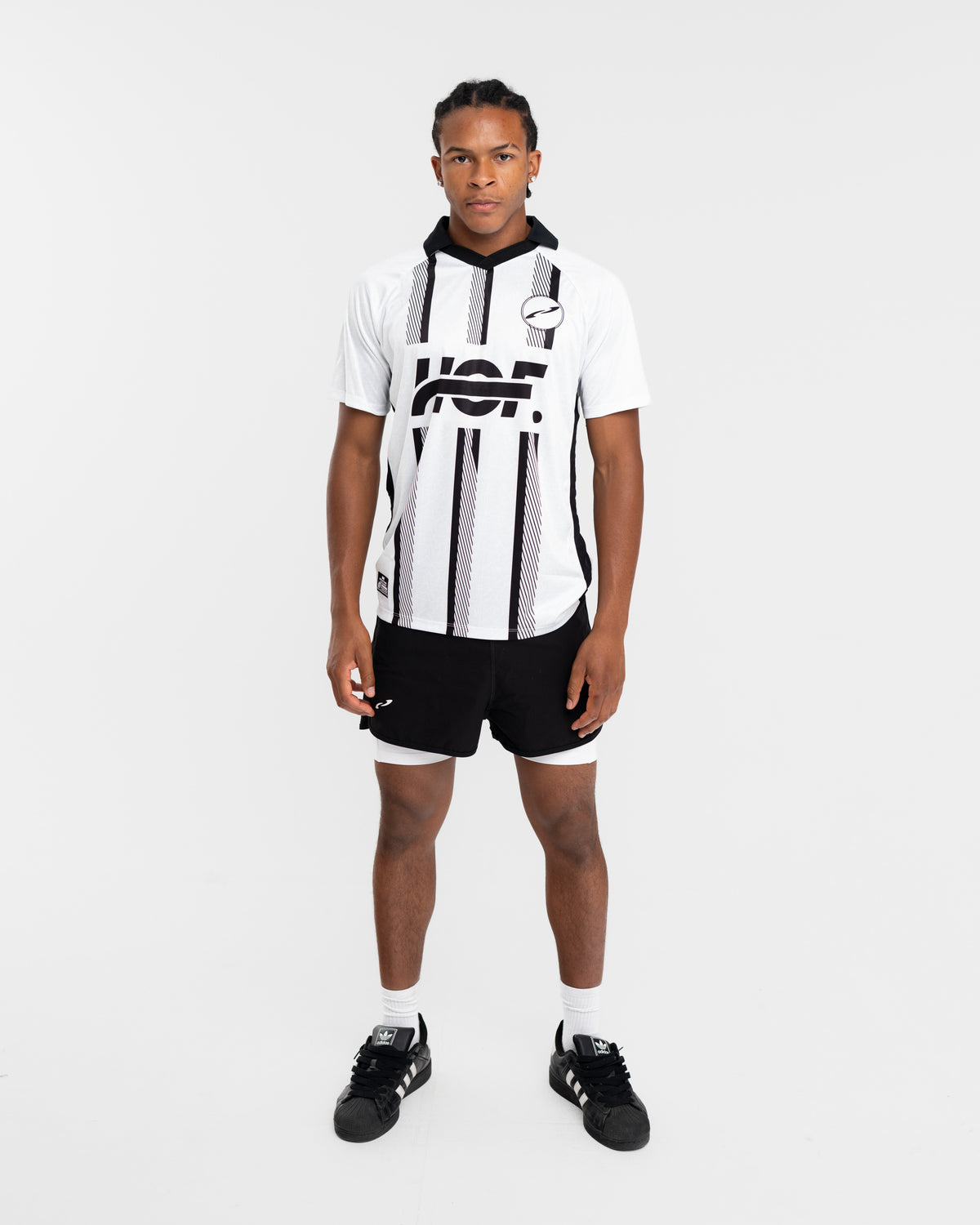 Homme portant le Legacy Performance Tee rayé avec un short noir, vue de face